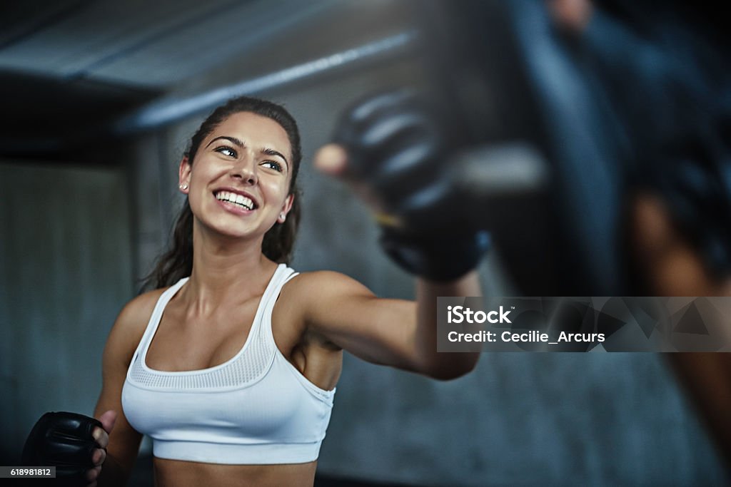 Shot of a young woman sparring with a boxing partner at the gym